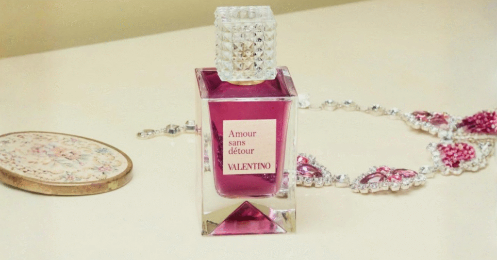 Flacon du parfum Amour Sans Désir de Valentino posé sur une table, entouré de bijoux.