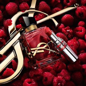 Flacon du parfum Libre Berry Crush de YSL Beauté entouré de framboises et d’un rouge à lèvres