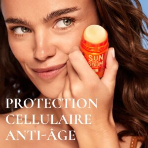Application du sérum solaire en stick SPF50 NUXE Sun sur le visage pour une protection UV ciblée
